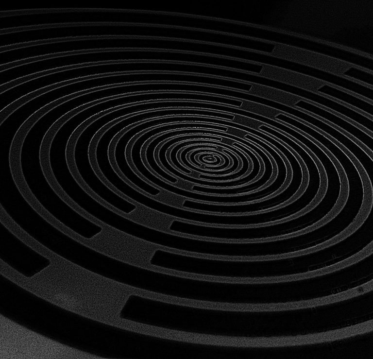 Schwarz-weiße Spiralmuster auf einer matten Oberfläche.